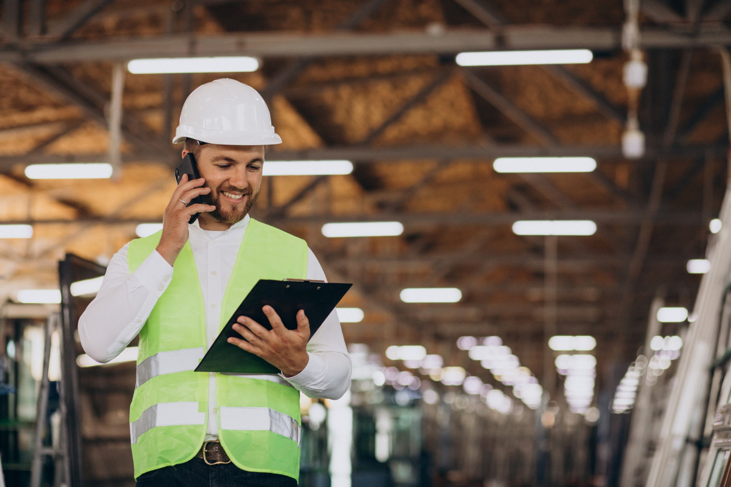 young-man-engineer-working-on-factory-making-order-on-the-phone young-man-engineer-working-on-factory-making-order-on-the-phone